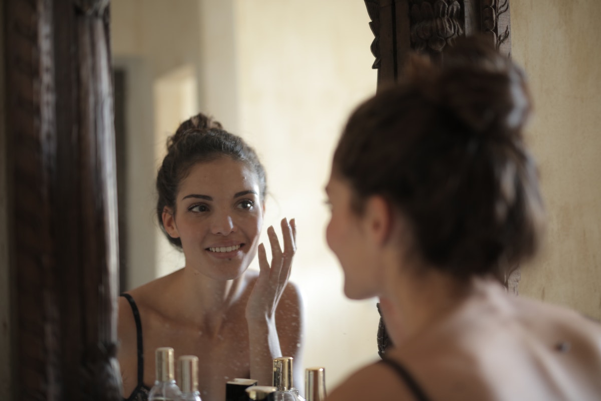 Egy fiatal nő a fürdőszobában bőrápoló olajokat használ. Bőrvédelem a téli hónapokban - Íme több, mint 50 E-vitaminban gazdag étel bőrünk egészségének megőrzéséhez