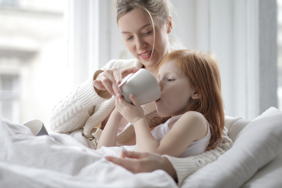 Egy anyuka gyógyteát itat gyermekével. Miben különbözik a vírusos és a bakteriális mandulagyulladás?
