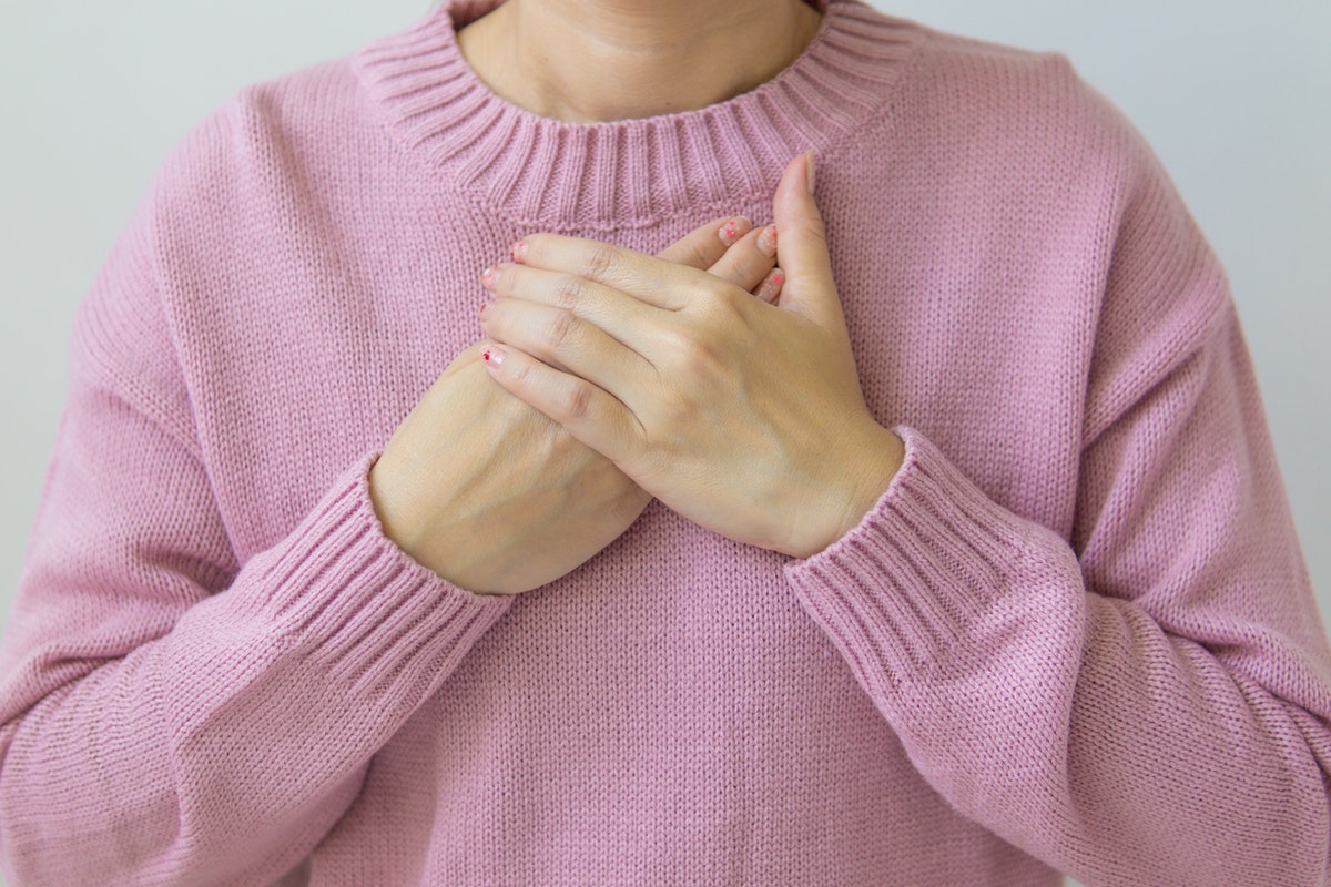 Egy nő a mellkasán tartja kezeit. Cisztás fibrózis - Okok, tünetek, és lehetséges kezelési módszerek